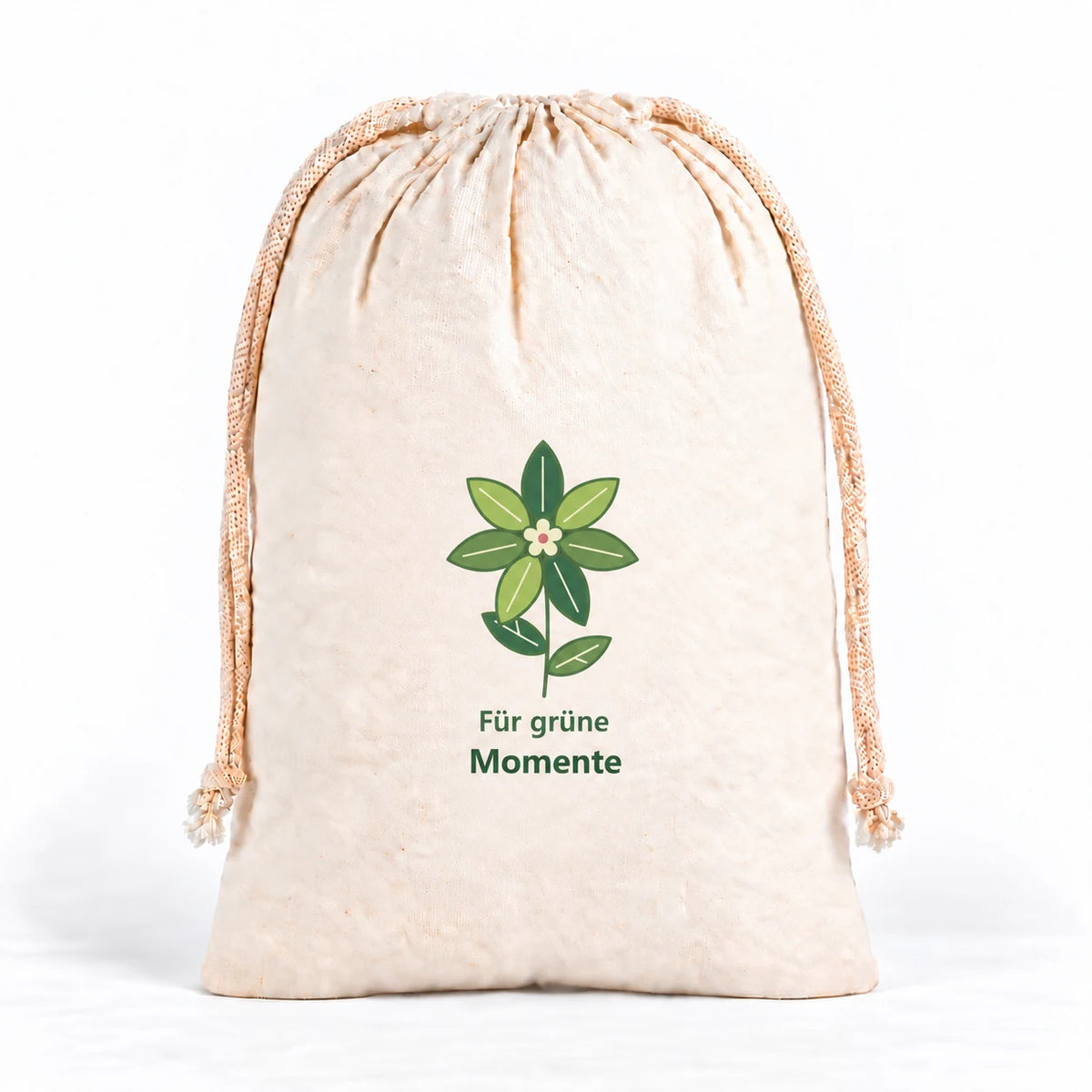 Naturfarbener Kordelzugbeutel mit einer stilisierten Blattblüte aus sieben grünen Blattpetalen, heller Blütenmitte, kleinem Rosépunkt und zwei Stielblättern. Darunter steht „Für grüne Momente“.