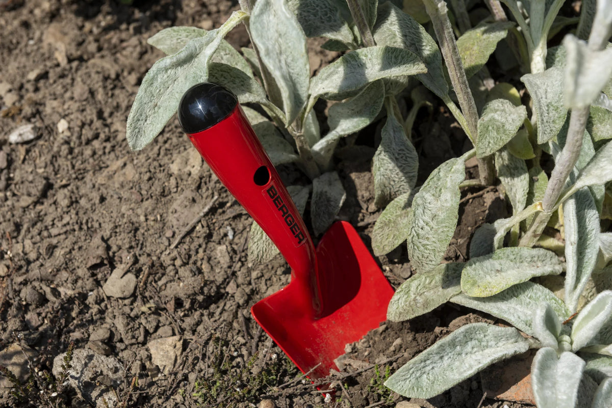 BERGER 5600 Pflanzkelle im Beet neben einer Staude.